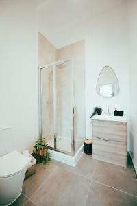 a bathroom with a shower and a toilet and a sink at Dusk House - Wyndale Living - B'ham JQ Townhouse in Birmingham