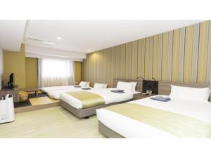 a hotel room with three beds and a television at La'gent Stay Hakodate Ekimae - Vacation STAY 88790v in Hakodate