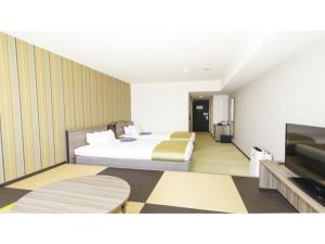 um quarto de hotel com duas camas e uma TV de tela plana em La'gent Stay Hakodate Ekimae - Vacation STAY 88790v em Hakodate