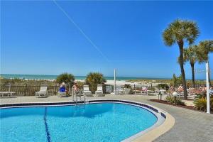 a swimming pool with a beach in the background at Oceanfront View of Madeira Beach, Steps to the Beach - Madeira Norte Condo in St Pete Beach
