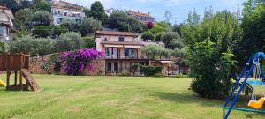 une maison sur une colline avec une aire de jeux dans une cour dans l'établissement Agriturismo PeterPan, à Pietra Ligure