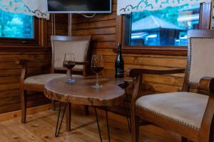 dos copas de vino en una mesa de madera con sillas en İstanbuldere Alabalıkevi, en Sapanca