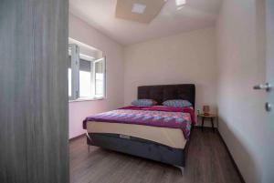 a bedroom with a bed in a room with a window at Apartmani Berdovic in Trebinje