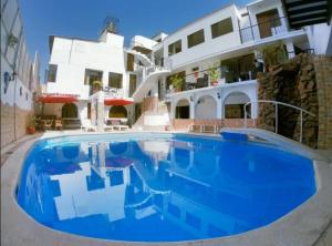 a large blue swimming pool in front of a building at Hotel San Isidro in Pisco