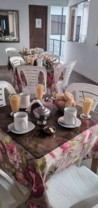 a table with cups and plates of food on it at Hotel San Isidro in Pisco