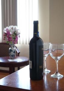 una botella de vino sentada en una mesa con dos copas en Hotel Lottus, en Quito