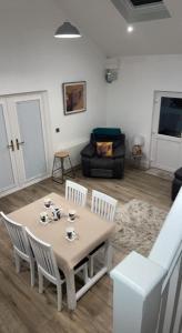 a living room with a table and chairs and a couch at Sèid Bò - Sleeps 6 - NEW Private 6 Person HotTub Available in Burnfoot