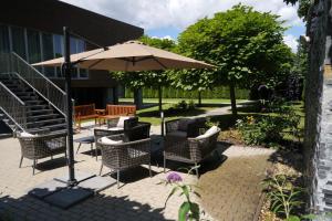 een patio met stoelen, een parasol en een trap bij Hotel Mousson in Michalovce