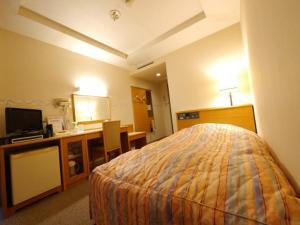 a hotel room with a bed and a desk and a television at Hotel Fukui Castle - Vacation STAY 58682v in Fukui