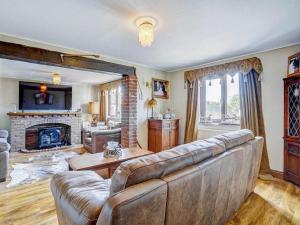 a living room with a couch and a fireplace at Melsham House in Freethorpe