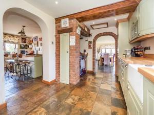 a kitchen with an archway and a brick wall at Melsham House in Freethorpe