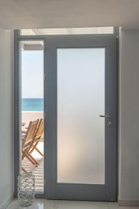 una puerta corredera de cristal con vistas a la playa en HH Bay, en Logaras