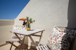 a table with a bird on it next to two chairs at BeGuest Parede Beach Apartment – Cascais in Parede