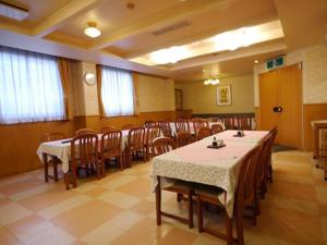 Hotel Fukui Castle - Vacation STAY 58705v في فوكوي: قاعة اجتماعات فيها طاولات وكراسي