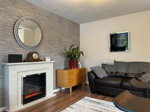 a living room with a couch and a fireplace at Pennies Retreat in Glossop