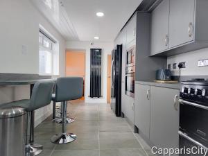 a kitchen with a counter and two chairs in it at Bridge Street Guest Rooms in Tranent