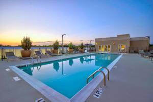 una piscina en un complejo con sillas y una puesta de sol en Courtyard by Marriott Nashville Green Hills en Nashville