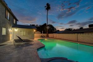 una piscina con un banco junto a una casa en Vegas Hideaway~Pool, Bar, Many beds~NEAR STRIP, en Las Vegas