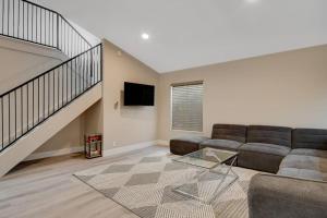 ein Wohnzimmer mit einem Sofa und einer Treppe in der Unterkunft Vegas Hideaway~Pool, Bar, Many beds~NEAR STRIP in Las Vegas