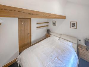 - une chambre avec un lit blanc et une armoire en bois dans l'établissement Three Peak Cottage, à Horton in Ribblesdale