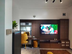 a living room with a television and a desk with a chair at Keev Homes & Apartments Shortlet in Port Harcourt