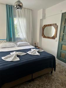 Un dormitorio con una cama azul con toallas. en Apelles Butik Otel, en Seferihisar
