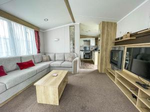 ein Wohnzimmer mit einem Sofa und einem TV in der Unterkunft Lovely 6 Berth Caravan At Caldecott Hall Country Park, Norfolk Ref 91010c in Great Yarmouth