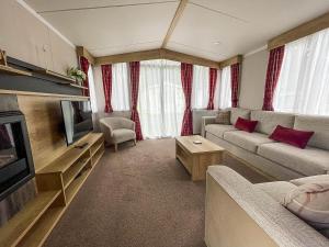 uma sala de estar com um sofá e uma televisão em Lovely 6 Berth Caravan At Caldecott Hall Country Park, Norfolk Ref 91010c em Great Yarmouth