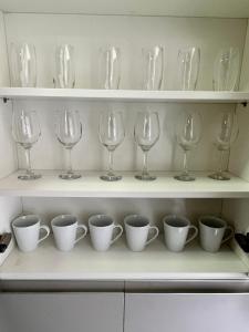 a row of wine glasses and cups on a shelf at Conforto Expo Center Norte in São Paulo