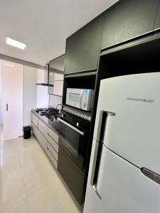 uma cozinha com um frigorífico e um micro-ondas em Conforto Expo Center Norte em São Paulo