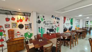 a restaurant with tables and chairs and a wall mural at Max Hotel in Arcoverde