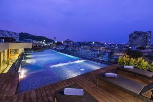 a swimming pool on top of a building at night at Citadines Grand Central Sri Racha - SHA Extra Plus in Si Racha