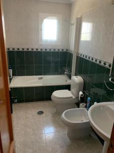 y baño con aseo, bañera y lavamanos. en Relaxing 3 bed 3 bath Villa for 8 Camposol Sect D, en Mazarrón