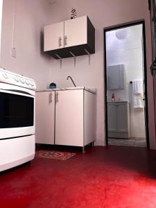 cocina con electrodomésticos blancos y suelo rojo en The stones house in the Historic Downtown, en Querétaro