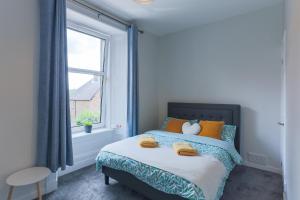 a bedroom with a bed with orange pillows and a window at Modern Craigie Apartment in Perth