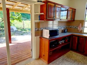 a kitchen with a counter top with a microwave at Dado's Place in Calibishie