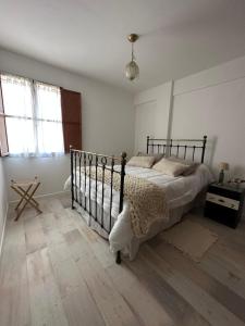 a bedroom with a bed and a wooden floor at Tu Hogar en Trelew I Calidez y practicidad in Trelew