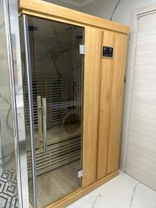 a wooden cabinet with a glass door in a room at Rijeka UrbanSPA in Rijeka