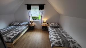 two beds in a small room with a window at Domki i Pokoje u Ilony in Krościenko