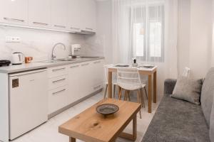 a kitchen and a living room with a couch and a table at Flonikos Apartmnets in Tsimándria