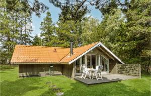 ホにあるHoliday Home Nørballevej Ivのポーチ、テーブル、椅子が備わる小さなキャビンです。 +13枚の写真