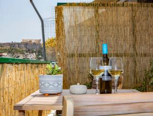 eine Flasche Wein und zwei Gläser auf einem Holztisch in der Unterkunft Dls*apartment in Athen