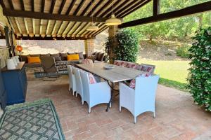 eine Terrasse mit Tisch und Stühlen unter einer Pergola in der Unterkunft Private villa with extensive gardens and pool in Lisciano Niccone