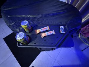 uma mesa com duas latas de refrigerante em Love Room avec Jacuzzi proche Paris et Roissy CDG em Persan