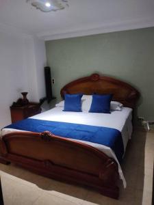 a bedroom with a large bed with blue pillows at bonito y bien ubicado apto. in Itagüí