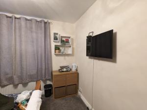 Zimmer mit einem Flachbild-TV an der Wand in der Unterkunft Large Cosy Room to Stay in South Reading in Shinfield