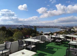 Galata istanbul Hotel في إسطنبول: صف من الطاولات والكراسي على شرفة مطلة