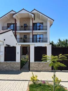 a large white house with a balcony and gates at TREND in Arad