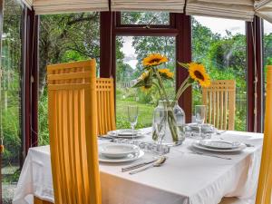 a table with a vase of sunflowers on it at Lavender Cottage in Kirkburton