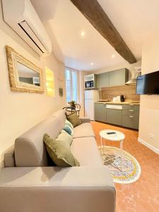 ein Wohnzimmer mit einem Sofa und einem Tisch in der Unterkunft Cosy & Chill Appartements - Au cœur du village de Cotignac, en Provence in Cotignac